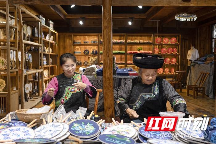 杨珍香（左）在苗绣基地工作。