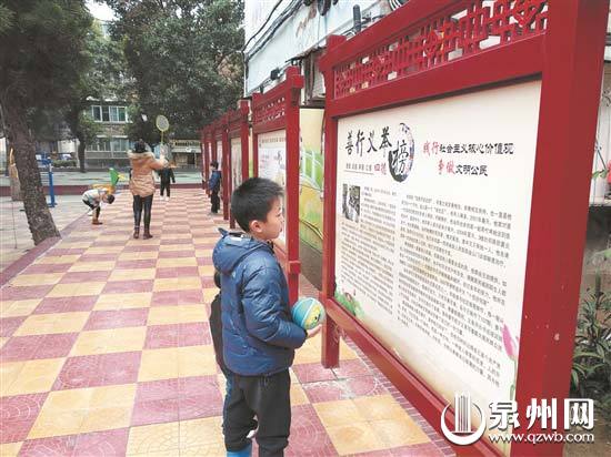 小朋友观看社区身边故事宣传栏 