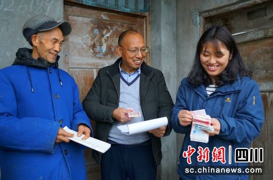 张丽萍和父亲上门给村民发工资。